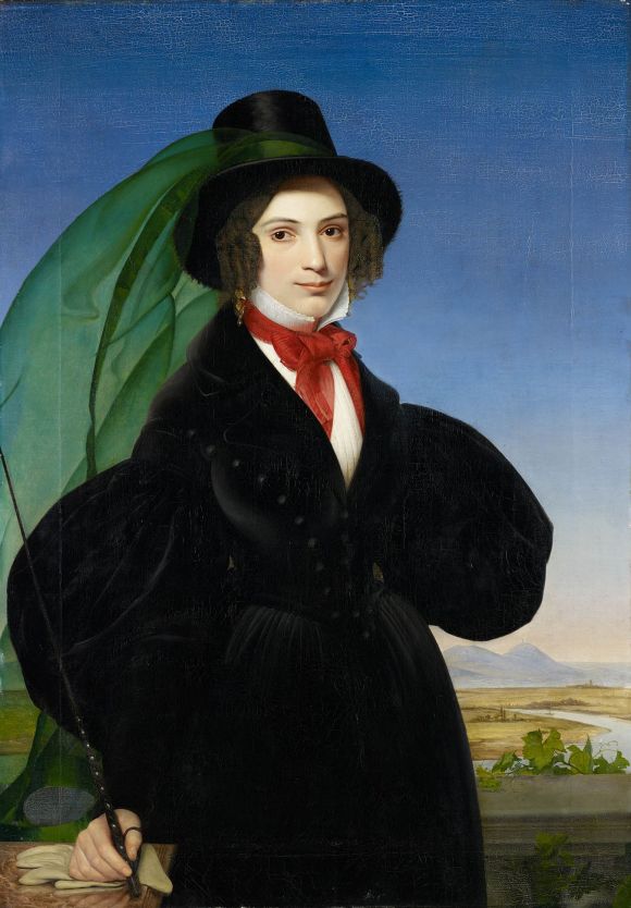 Dreiviertelporträt einer jungen Frau in einem schwarzen Kleid mit schwarzen Zylinder und Reitgerte in der Hand.