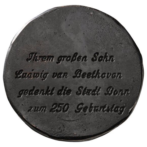 Schwärzliche Medaille mit vierzeiliger Inschrift.